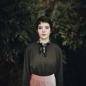 a woman standing in front of a tree